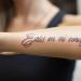 Tatuering med en inskription på armen med en översättning